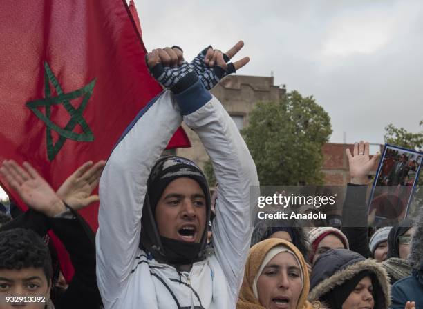 People shouts slogans and hold Flag of Morocco as they gather at Jerada city center during a demonstration demanding the fulfillment of government's...