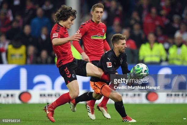 Goalkeeper Ron-Robert Zieler of Stuttgart is challenged by Caglar Souyuencue and Nils Petersen of Freiburg during the Bundesliga match between...