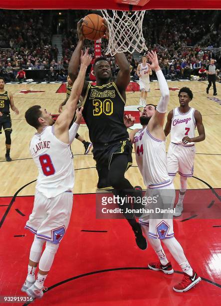 Julius Randle of the Los Angeles Lakers shoots btween Zach LaVine and Nikola Mirotic of the Chicago Bulls at the United Center on January 26, 2018 in...