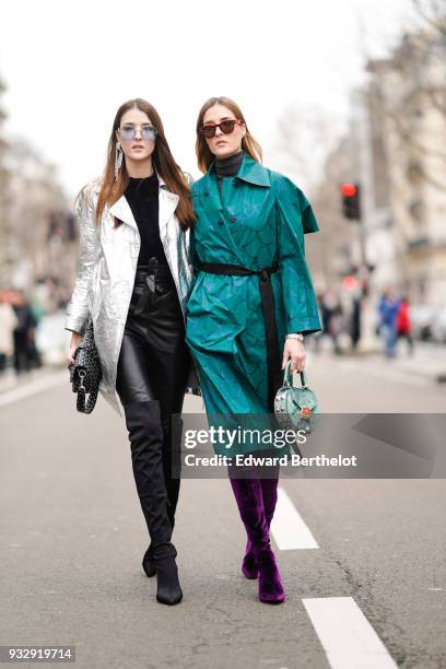 Guest wears sunglasses, one large earring, a black top, a glossy silver coat, black leather skinny pants, a black studded handbag, black suede...