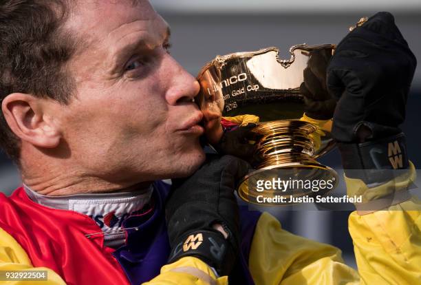 Richard Johnson holds the Gold Cup after riding Native River to victory in the Timico Cheltenham Gold Cup Chase at the Cheltenham Festival at...