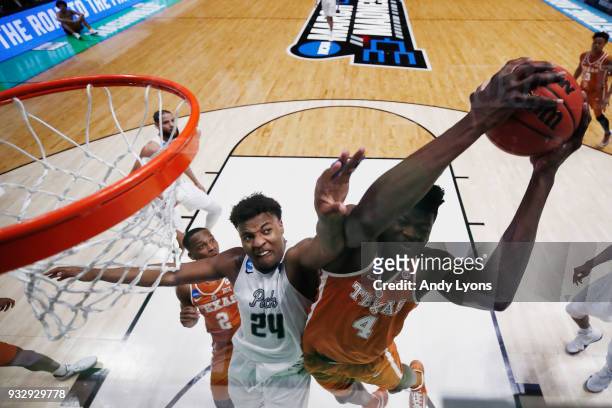 Mohamed Bamba of the Texas Longhorns grabs a rebound from Jordan Caroline of the Nevada Wolf Pack during the game in the first round of the 2018 NCAA...
