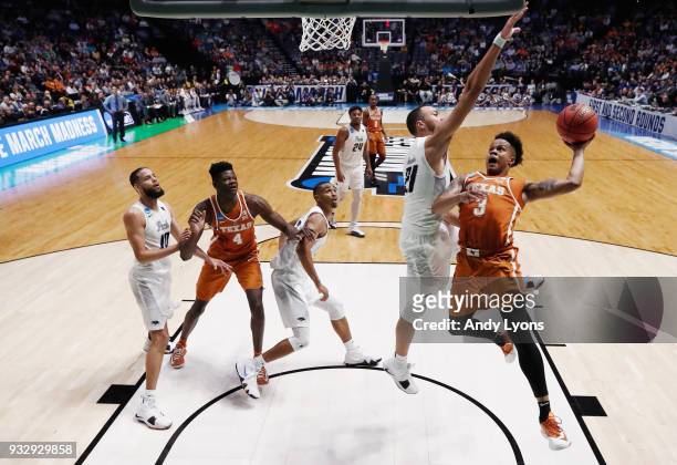 Jacob Young of the Texas Longhorns goes up for a layup defended by Kendall Stephens of the Nevada Wolf Pack during the game in the first round of the...