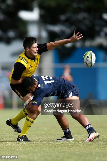 Liam Mitchell of the Hurricanes passes in the tackle of Tumua Manu of the Blues A Team during the development squad trial match between the...