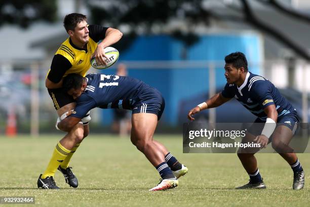 Liam Mitchell of the Hurricanes passes in the tackle of Tumua Manu of the Blues A Team during the development squad trial match between the...