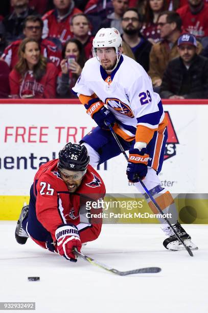 Devante Smith-Pelly of the Washington Capitals and Brock Nelson of the New York Islanders battle for the puck in the first period at Capital One...