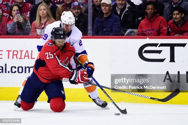 Devante Smith-Pelly of the Washington Capitals and Brock Nelson of the New York Islanders battle for the puck in the first period at Capital One...