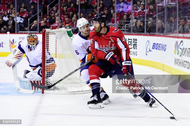 Brooks Orpik of the Washington Capitals controls the puck against Ryan Pulock of the New York Islanders in the first period at Capital One Arena on...