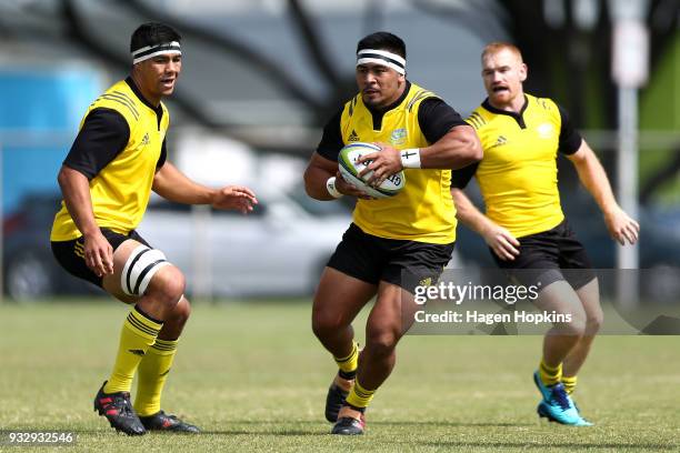 Asafo Aumua of the Hurricanes makes a break while Reed Prinsep and Jamie Booth look on during the development squad trial match between the...