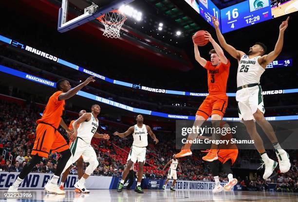 Jimmy Sotos of the Bucknell Bison battles for the ball with Kenny Goins of the Michigan State Spartans during the first half in the first round of...