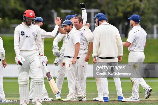 Matt McEwan of the Auckland Aces is congratulated by team mates after dismissing Chad Bowes of Canterbury during the Plunket Shield match between...