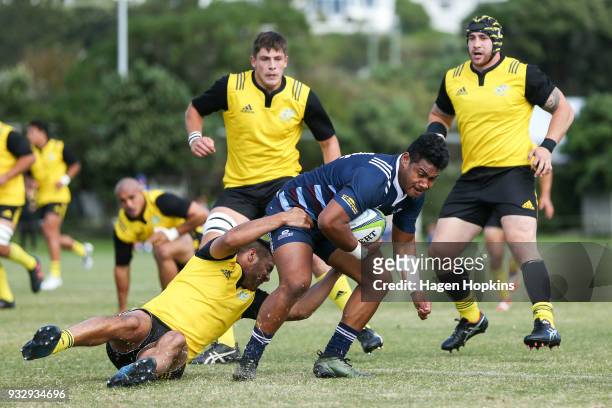 Loketi Manu of the Blues A Team is tackled by Chase Tiatia of the Hurricanes during the development squad trial match between the Hurricanes and the...