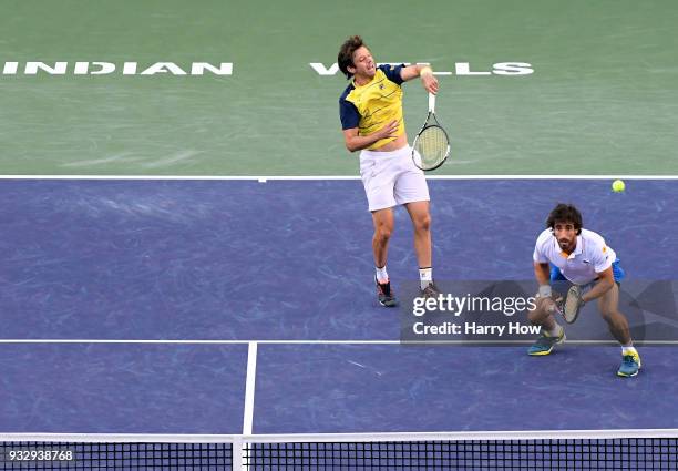 Horacio Zeballos of Argentina hits an overhead in front of partner Pablo Cuevas of Uruguay in their semifinal loss to Bob Bryan and Mike Bryan of the...