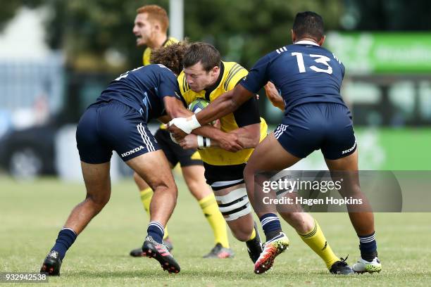 Murray Douglas of the Hurricanes is tackled during the development squad trial match between the Hurricanes and the Blues at Evans Bay Park on March...