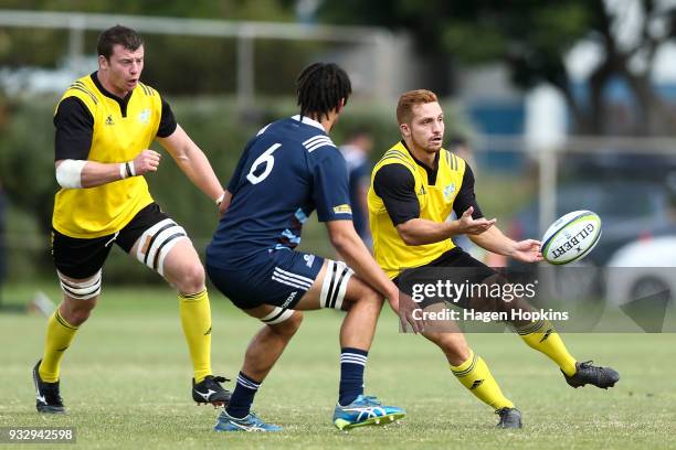 Ihaia West of the Hurricanes passes under pressure from Waimana Riedlinger-Kapa of the Blues A Team during the development squad trial match between...