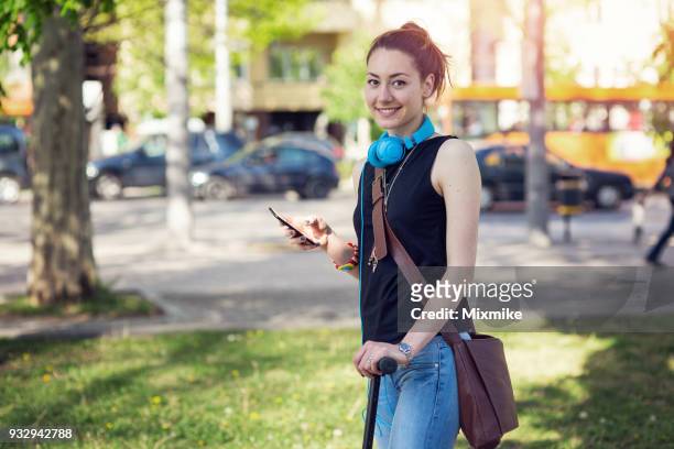 glimlachend vrouwelijke online berichten op haar telefoon - 2017 common good forum stockfoto's en -beelden