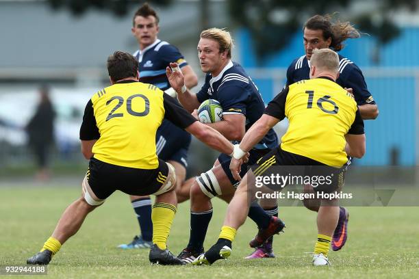 Matt Matich of the Blues A Team runs at Will Mangos and James O'Rielly of the Hurricanes during the development squad trial match between the...