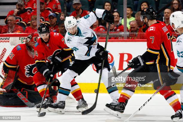 Travis Hamonic of the Calgary Flames skates against Melker Karlsson of the San Jose Sharks during an NHL game on March 16, 2018 at the Scotiabank...