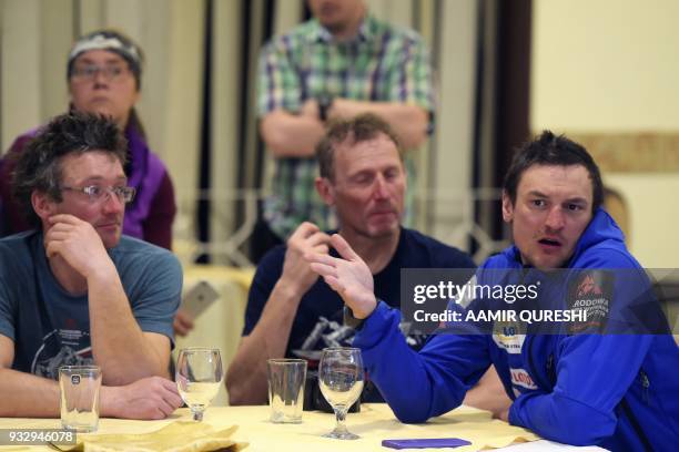 This picture taken on March 16, 2018 shows Polish climber Adam Bielecki flanked by his team members as he shares his team's experience after...