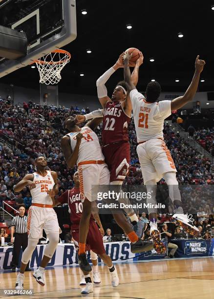 Eli Chuha of the New Mexico State Aggies shoots against Elijah Thomas and Anthony Oliver II of the Clemson Tigers in the first half in the first...