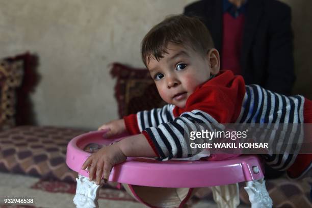 This picture taken on March 16, 2018 shows Afghan toddler Donald Trump, who is aged around 18 months, playing at his home in Kabul. Donald Trump...