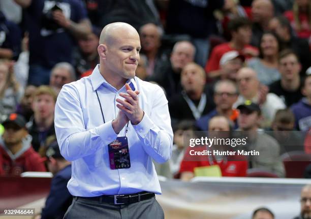Head coach Cael Sanderson of the Penn State Nittany Lions smiles and applauds after Mark Hall won his match by fall during session four of the NCAA...