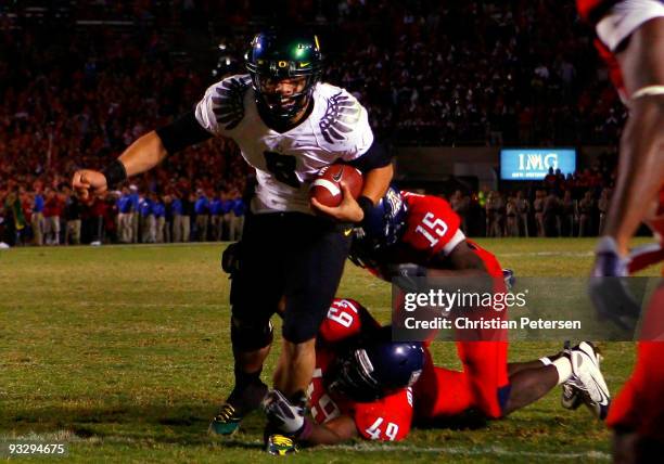 Quarterback Jeremiah Masoli of the Oregon Ducks rushes in the game winning touchdown in the second overtime past Earl Mitchell and Xavier Kelley of...