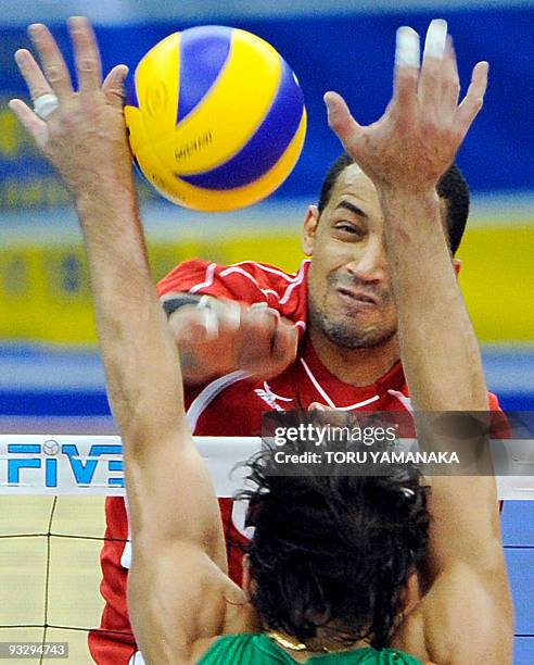 Abdel Latif Ahmed of Egypt spikes the ball through Gilberto Godoy Filho of Brazil during their match at the men's Grand Championship Cup volleyball...