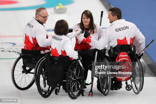 Dennis Thiessen, Marie Wright, Mark Ideson and Ina Forrest of Canada gather in a circle during the Curling Mixed Bronze Medal match between South...