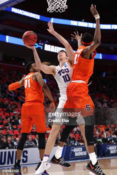Vladimir Brodziansky of the TCU Horned Frogs drives to the basket against Oshae Brissett and Paschal Chukwu of the Syracuse Orange during the second...