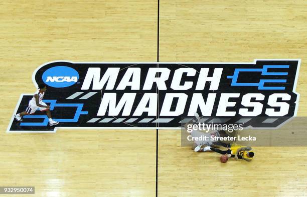 Jairus Lyles of the UMBC Retrievers and Isaiah Wilkins of the Virginia Cavaliers dive for a loose ball during the first round of the 2018 NCAA Men's...