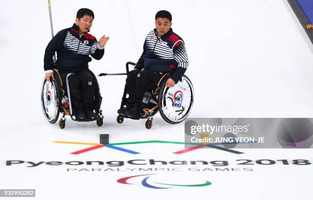 South Korea's Lee Dong-ha and Cha Jae-goan talk during the wheelchair curling bronze medal game between South Korea and Canada at the Gangneung...