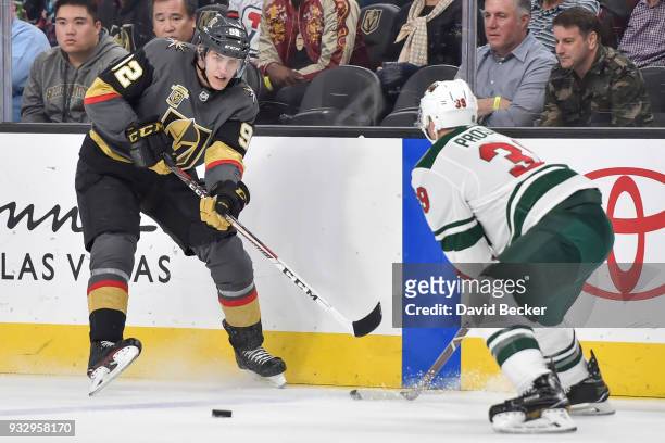 Tomas Nosek of the Vegas Golden Knights passes the puck with Nate Prosser of the Minnesota Wild defending during the game at T-Mobile Arena on March...