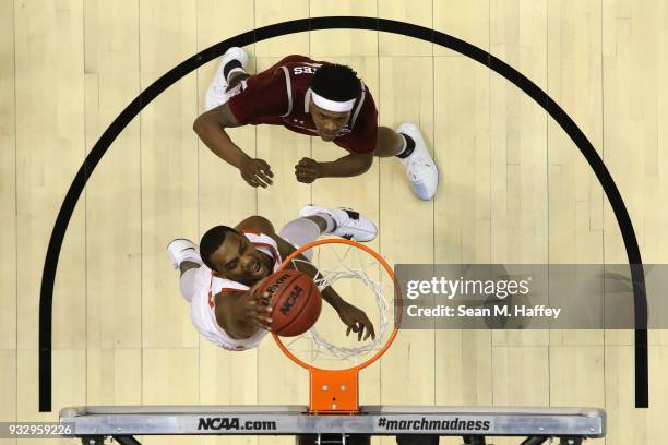 Aamir Simms of the Clemson Tigers dunks against Jemerrio Jones of the New Mexico State Aggies in the first half in the first round of the 2018 NCAA...