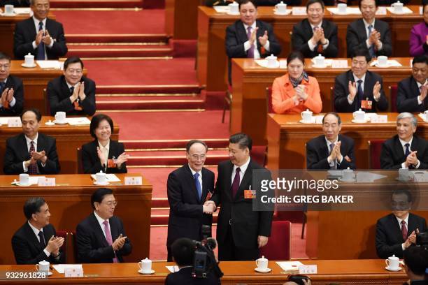 Wang Qishan , former secretary of the Central Commission for Discipline Inspection, shakes hands with China's President Xi Jinping after Wang was...