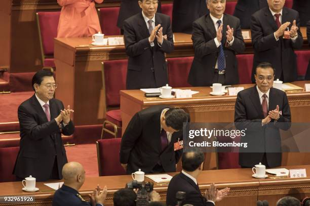 Xi Jinping, China's president, center, bows as Zhang Dejiang, chairman of the Standing Committee of the National People's Congress , left, and Li...