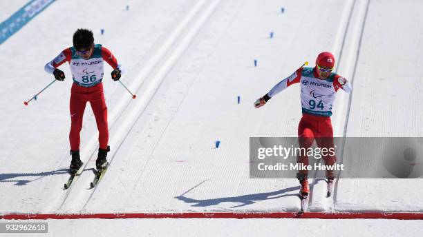 Keiichi Sato of Japan crosses the finishing line ahead of fellow countryman Keigo Iwamoto the Men's Cross Country Skiing 10km Standing on day eight...