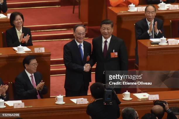 Reelected Chinese President Xi Jinping and newly elected Chinese Vice President Wang Qishan shake hands after hearing the results of the election...