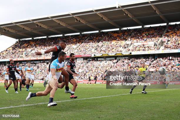 David FusituÕa of the Warriors chases the ball down against Michael Gordon of the Titans during the round two NRL match between the New Zealand...