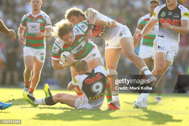 George Burgess of the Rabbitohs is tackled by Peter Wallace and James Fisher-Harris of the Panthers during the round two NRL match between the...