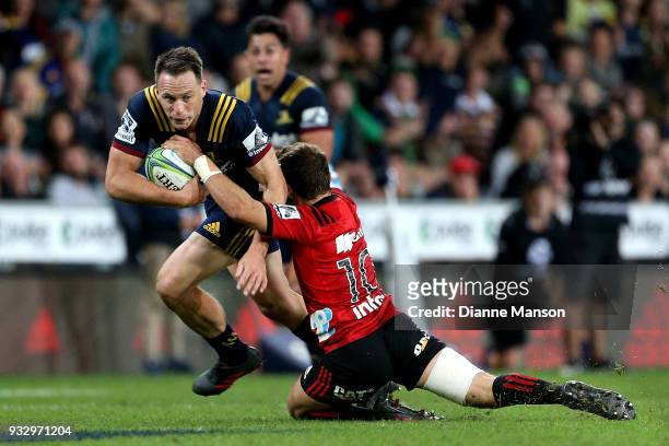 Ben Smith of the Highlanders is tackled by Mitchell Hunt of the Crusaders during the round five Super Rugby match between the Highlanders and the...