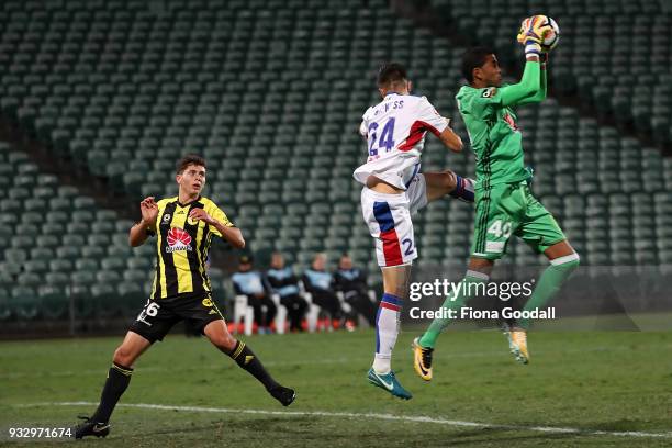 Tando Velaphi goal keeper of the Wellington Phoenix takes the ball with Joseph Champness of the Newcastle Jets and Liberato Cacace of the Wellington...