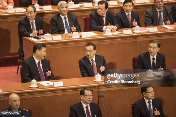 Xi Jinping, China's president, second row left, speaks to Li Keqiang, China's premier, second row center, and Wang Yang, China's vice premier, second...