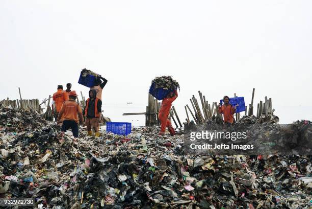 Workers collect trash during a clean up of the waters of Jakarta Bay on March 2018 in Jakarta, Indonesia. Jakarta's waters are polluted, contributing...
