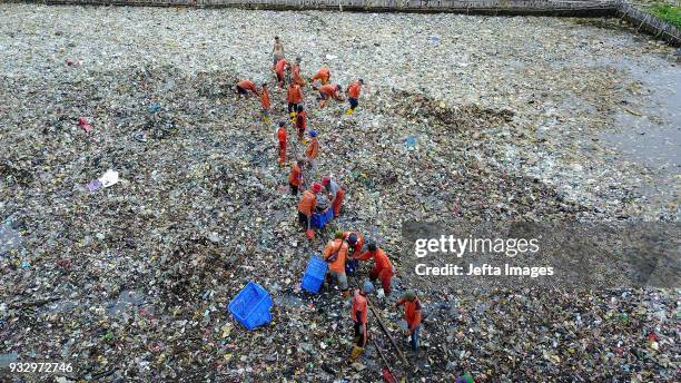 Workers collect trash during a clean up of the waters of Jakarta Bay on March 2018 in Jakarta, Indonesia. Jakarta's waters are polluted, contributing...