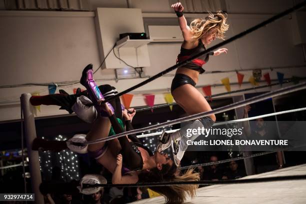 Female wrestlers are pictured during a show on March 11 in Nanterre, near Paris. - In Nanterre, the French Association of Professional Wrestling...