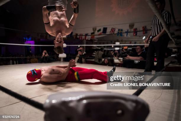 Wrestlers are pictured during a show on March 11 in Nanterre, near Paris. In Nanterre, the French Association of Professional Wrestling revives...