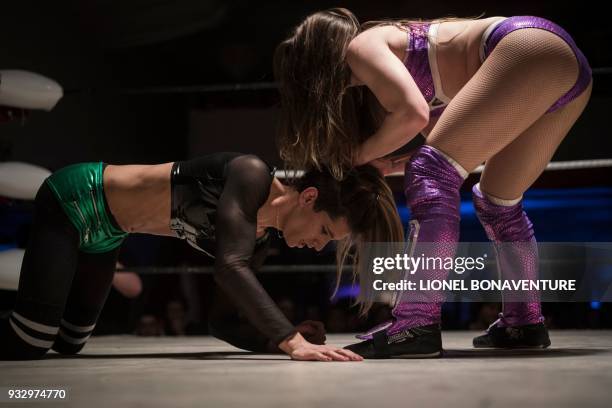 Female wrestlers are pictured during a show on March 11 in Nanterre, near Paris. In Nanterre, the French Association of Professional Wrestling...