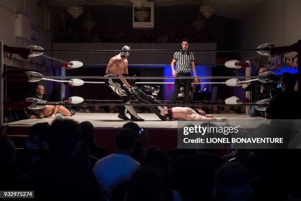 Wrestlers are pictured during a show on March 11 in Nanterre, near Paris. In Nanterre, the French Association of Professional Wrestling revives...