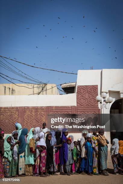 Kano, Nigeria- Girls wait in line to receive alms after Friday prayers in Kano, Nigeria on Friday, January 19, 2018.